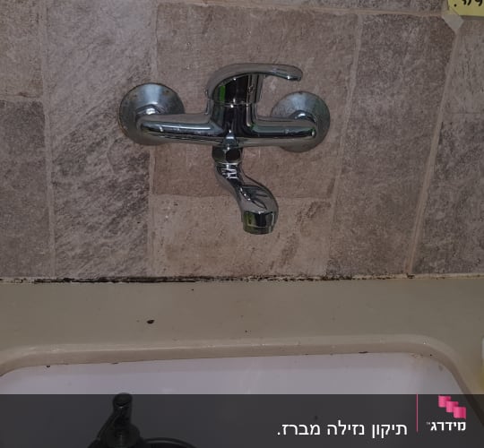 ברז מים מעל כיור במטבח